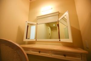 a bathroom with a mirror and a wooden dresser at Hotel Marital Sousei Kurume in Kurume