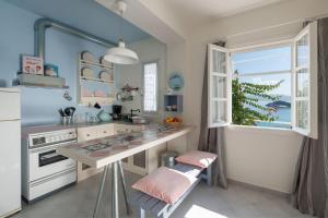 a kitchen with a counter and a window and a table at Kimolian Houses in Kimolos