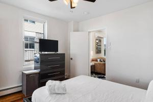 a bedroom with a bed and a flat screen tv at Beach House Style 1BR Parking near Beach in Ventnor City