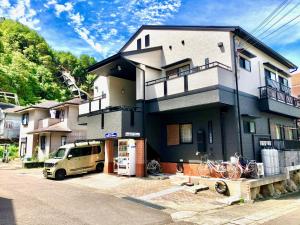 ein Haus mit einem Van davor geparkt in der Unterkunft Midtown Sakura Apartment House 202 予約者だけの空間 A space just for you in Nachikatsuura