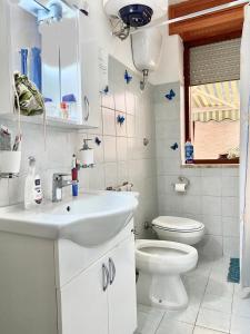 uma casa de banho com um lavatório branco e um WC. em A Casa di Luca em Gallipoli