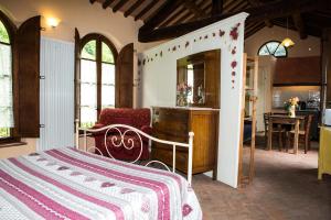 a bedroom with a bed and a table and a kitchen at A Casa Del Tosi in Lucca