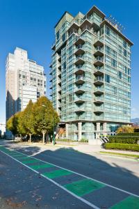 a large building with a parking lot in front of it at Lord Stanley Suites On The Park in Vancouver