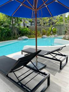 una mesa con sillas y una sombrilla junto a la piscina en New Cosy Apartment at Marvest Huahin City Center, en Hua Hin