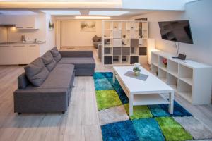 a living room with a couch and a table at Innsbruck City Center Duplex I 24h self-check-in in Innsbruck