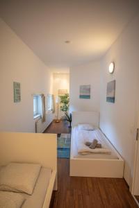 a white bedroom with a bed and a couch at Innsbruck City Center Duplex I 24h self-check-in in Innsbruck