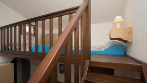 una escalera de madera en una casa con lámpara en Welcomely - Stella Marina Blu, en Cala Liberotto