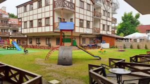 a playground in front of a large building with a slide at Rowy Vasco da Gama in Rowy