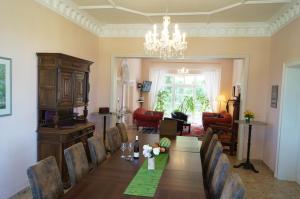 a dining room with a table with chairs and a chandelier at Villa Unger in Kurort Altenberg