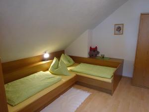 sypialnia z 2 łóżkami i zielonymi poduszkami w obiekcie Haus ÖtscherTeufel w mieście Lackenhof