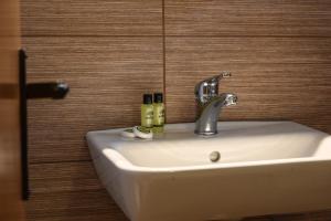 a bathroom sink with a faucet and two bottles on it at Hotel Geromichalos in Paralía Skotínis +56 photos