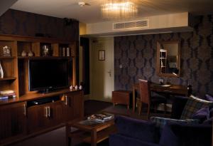 a living room with a couch and a television and a table at Hotel Du Vin Edinburgh in Edinburgh