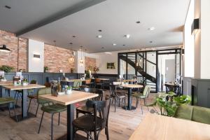 ein Restaurant mit Tischen und Stühlen und eine Treppe in der Unterkunft Hof van Holland Hotel in Edam