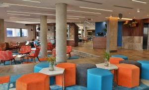 a lobby with orange and blue chairs and tables at Town Lodge Umhlanga in Durban