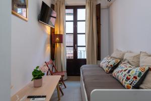 een woonkamer met een bank en een tafel bij Apartamentos Vado - San Matías alto in Granada