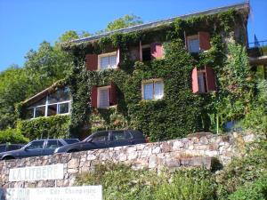 un edificio ricoperto di edera con macchine parcheggiate di fronte di Gite la LITBERE a Campan