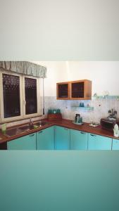 eine Küche mit blauen Schränken und einem Fenster in der Unterkunft Villa Floridia in Santa Maria Del Focallo