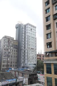 a tall white building in a city with buildings at Hotel Cliffton in Mumbai