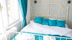 a bed with blue and white sheets and pillows at Old Town Square Apartment Novi Sad in Novi Sad