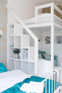 a bedroom with a white bunk bed with a blue blanket at Old Town Square Apartment Novi Sad in Novi Sad