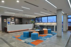 a lobby with blue and orange seating in a building at Town Lodge Umhlanga in Durban