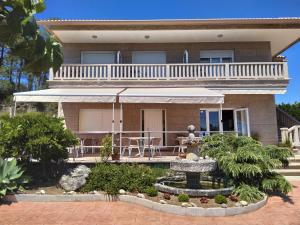 a house with a balcony and a table and chairs at Pension Playa Mar Cachadiñas in Balea