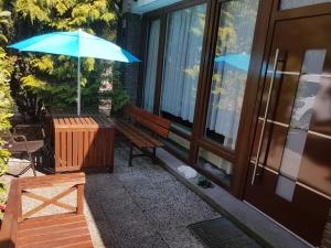 un banc avec un parasol à côté d'un bâtiment dans l'établissement Ferienwohnung Fellnasen WG, à Krefeld