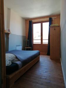a bedroom with a bed and a large window at File dans ta chambre ! in Le Monastier sur Gazeille