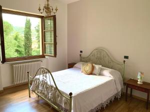 łóżko w sypialni z dużym oknem w obiekcie Agriturismo La Collina Toscana w mieście Pieve a Maiano