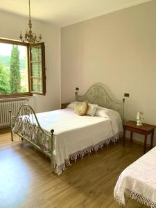 a bedroom with a bed and a table and a window at Agriturismo La Collina Toscana in Pieve a Maiano