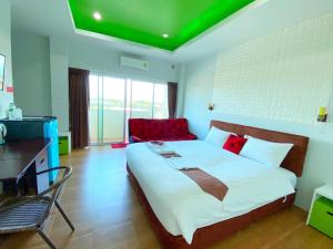 um quarto com uma cama grande e um sofá vermelho em Namthip Residence em Trang