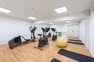 a gym with exercise bikes and a yellow ball at Eurostars Mediterranea Plaza in Alicante