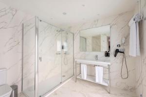 a bathroom with a shower, sink, and tub at Eurostars Mediterranea Plaza in Alicante