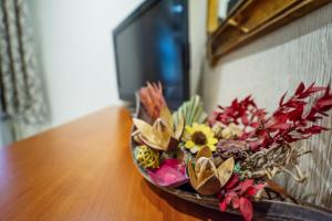 Un cuenco lleno de flores sobre una mesa de madera. en Casa Ivett, en Brasov