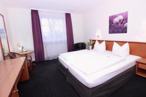 ein Hotelzimmer mit einem großen Bett und einem Fenster in der Unterkunft Landhotel Hirsch in Kempten