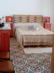 1 dormitorio con cama, muebles de madera y alfombra en la casa della capretta, en SantʼAntìoco