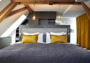 a bedroom with a large bed with yellow pillows at Sorell Hotel Seefeld in Zurich