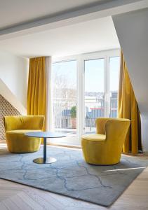 チューリッヒにあるソレル ホテル ゼーフェルトのリビングルーム(黄色い椅子2脚、テーブル付)