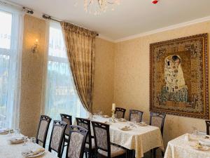 a restaurant with tables and chairs and a painting on the wall at Villa San Marino in Vorzelʼ
