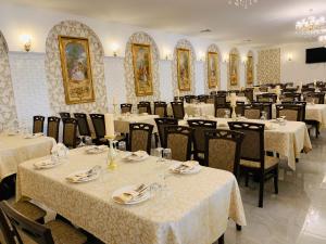 a dining room with tables and chairs with white table cloth at Villa San Marino in Vorzelʼ