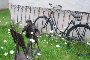 a statue of a person sitting on a bench next to a bike at City Appartement in Bad Radkersburg