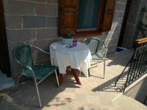 Machi's Guest House في ميثيمنا: طاولة عليها كرسيين وطاولة عليها كوب