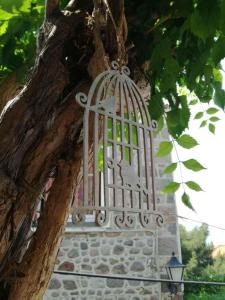 um pássaro numa gaiola pendurado numa árvore em Machi's Guest House em Mithimna