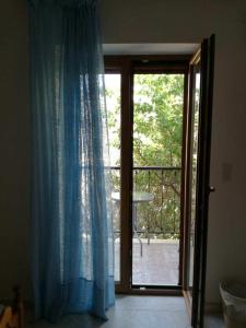 a room with a sliding glass door to a balcony at Machi's Guest House in Mythimna