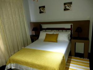 a bedroom with a white bed with a yellow pillow at Flight Inn in Margate