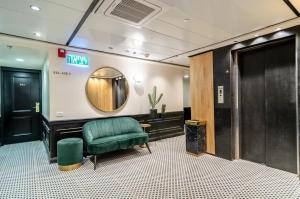 a waiting room with a green chair and a mirror at Royal Plaza Hotel in Tiberias