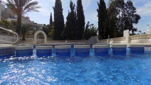 a large swimming pool with blue and white chairs at Bungalow CASIOPEA Internet 300 Mb SAT SMARTTV in El Campello
