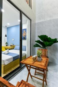a bedroom with a bed and a wooden table and a table sidx sidx at Cozrum Homes Ambera House in Ho Chi Minh City