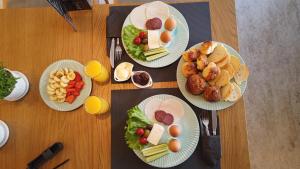 vier Teller Essen auf einem Holztisch in der Unterkunft L'Hotel in Prizren