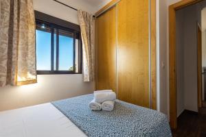 ein Schlafzimmer mit einem Bett mit zwei Handtüchern darauf in der Unterkunft APARTAMENTO BOLONIA SUR B in Tarifa